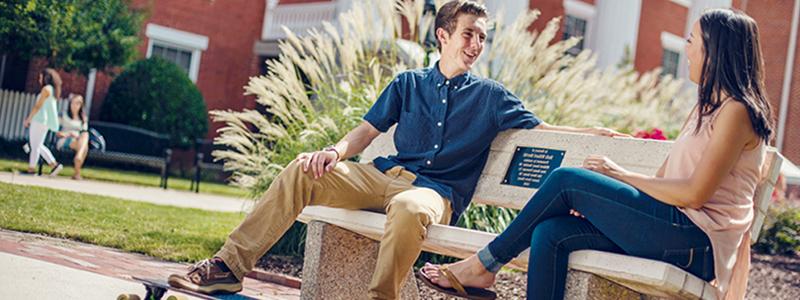 two students sitting on a bench